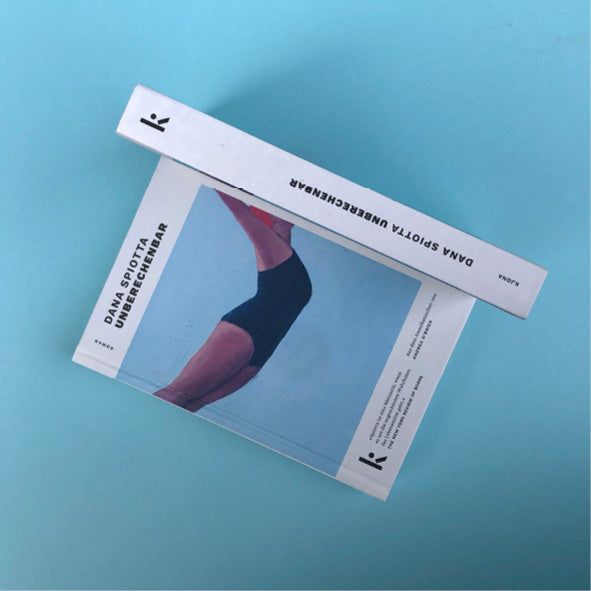 Foto von »Unberechenbar«, unten Cover von vorne, darüber aufgestellt der Buchrücken.