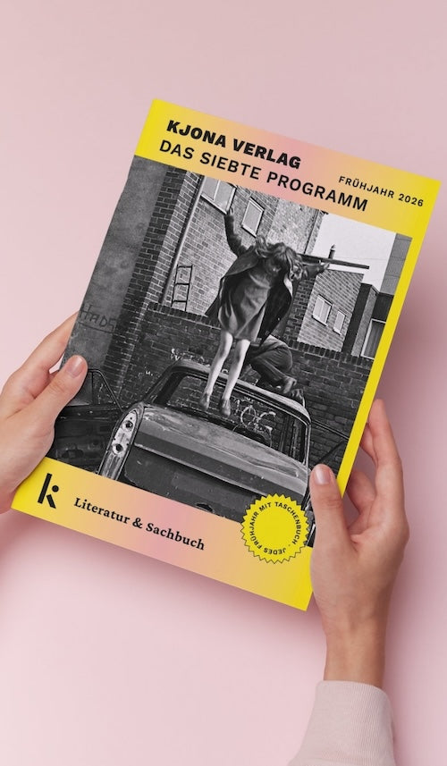 Zwei Hände halten den Katalog 'KJONA VERLAG DAS SIEBTE PROGRAMM FRÜHJAHR 2026' vor einem pinken Hintergrund. Das Cover zeigt ein Schwarz-Weiß-Bild einer Person, die auf einem Autodach springt, und hebt 'Literatur & Sachbuch' hervor.