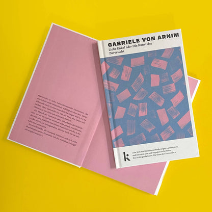 Foto von »Liebe Enkel oder die Kunst der Zuversicht«, aufgeschlagen im Hintergrund mit Klappentext, Cover im Vordergrund. 