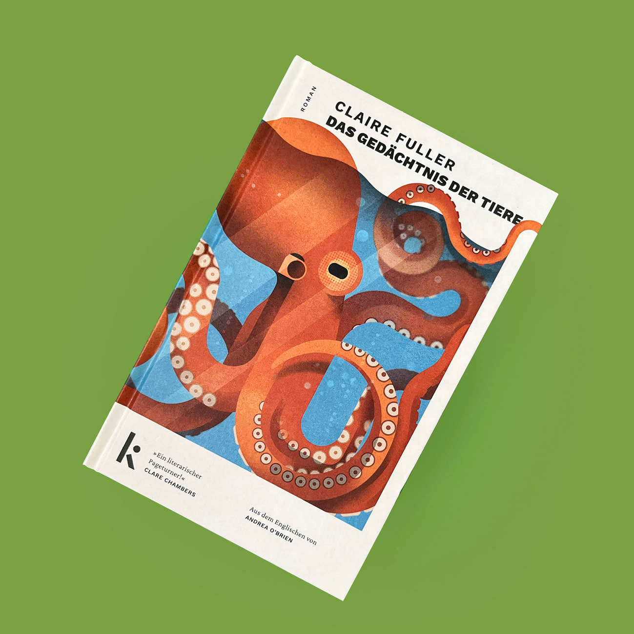 Das Buch „Das Gedächtnis der Tiere“ von Claire Fuller liegt flach und leicht schräg auf einer grünen Oberfläche. Zu sehen ist die Cover-Vorderseite des Hardcovers mit der großen Illustration eines Kraken, dem Titel am oberen Rand und dem schwarzen Verlagslogo von kjona unten links.