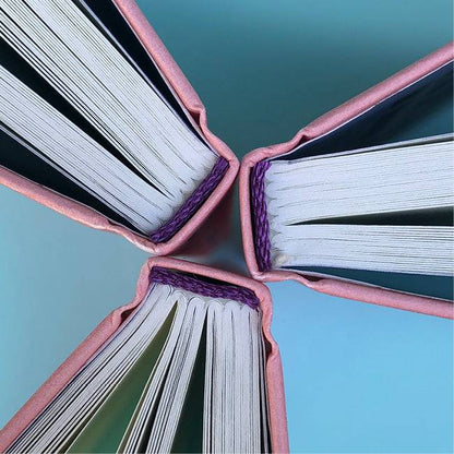 Ausschnitte der Buchseiten von »Kleine Kratzer«, drei Bücher Rücken an Rücken, von oben. 