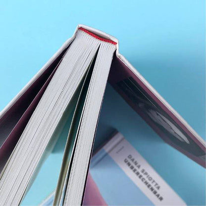 Foto von »Unberechenbar«, aufgestellt von oben im Vordergrund, Teil des Covers verschwommen im Hintergrund. 