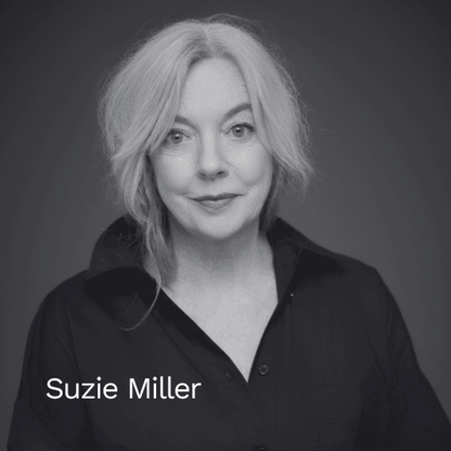 Schwarz-weiß Porträt der Autorin Suzie Miller vor einem dunklen Hintergrund. Sie blickt freundlich in die Kamera und trägt ein dunkles Hemd mit offenem Kragen.