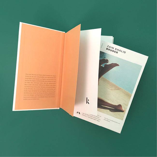 Foto von »Bruder«, ein Buch aufgeschlagen, eins zu zwischen die Seiten geschoben. 